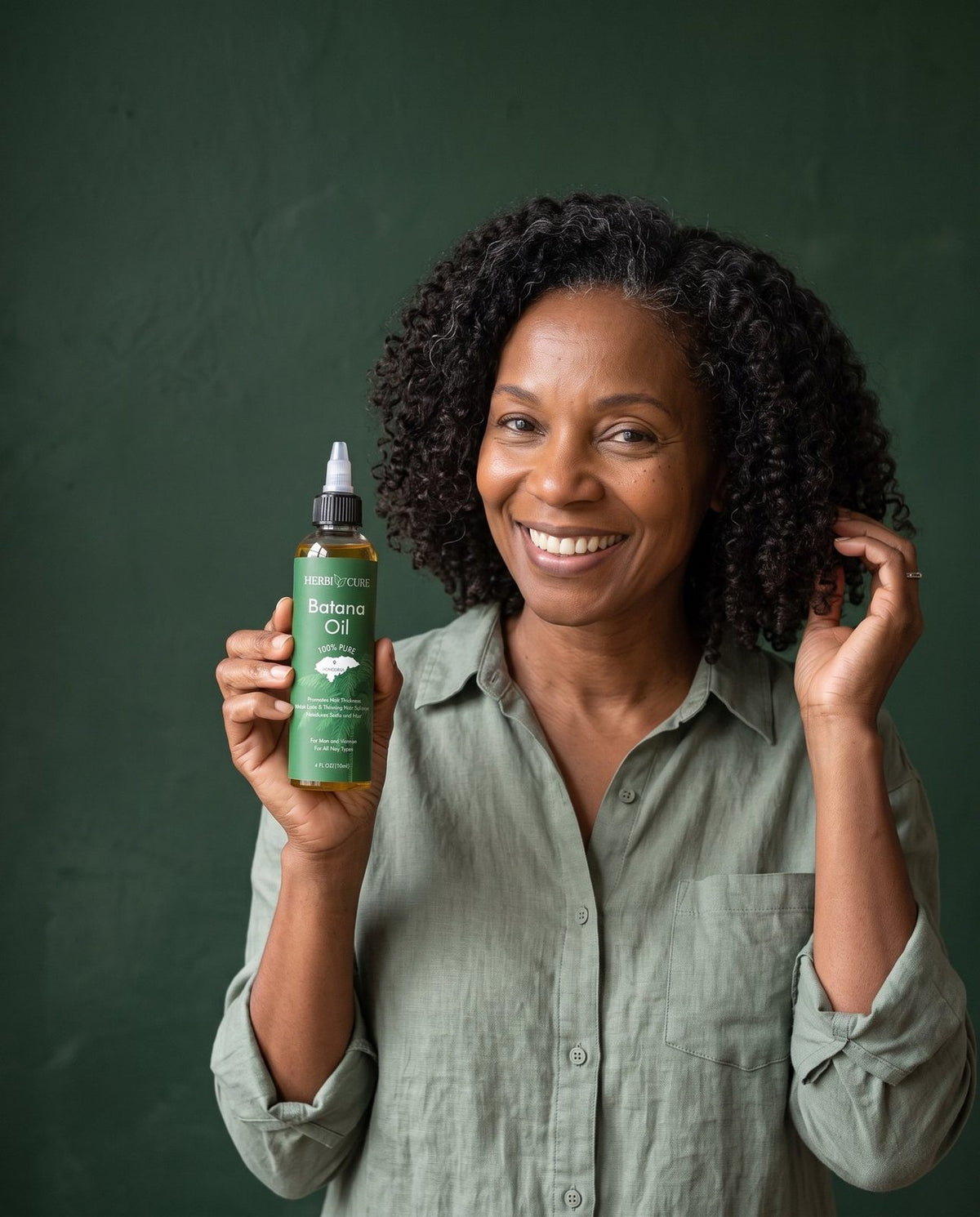 Smiling woman holding HerbiCure Batana Oil