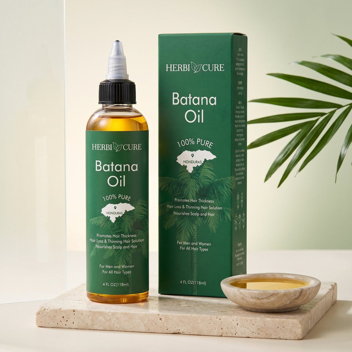 HerbiCure Batana Oil bottle and box on a stone plinth
