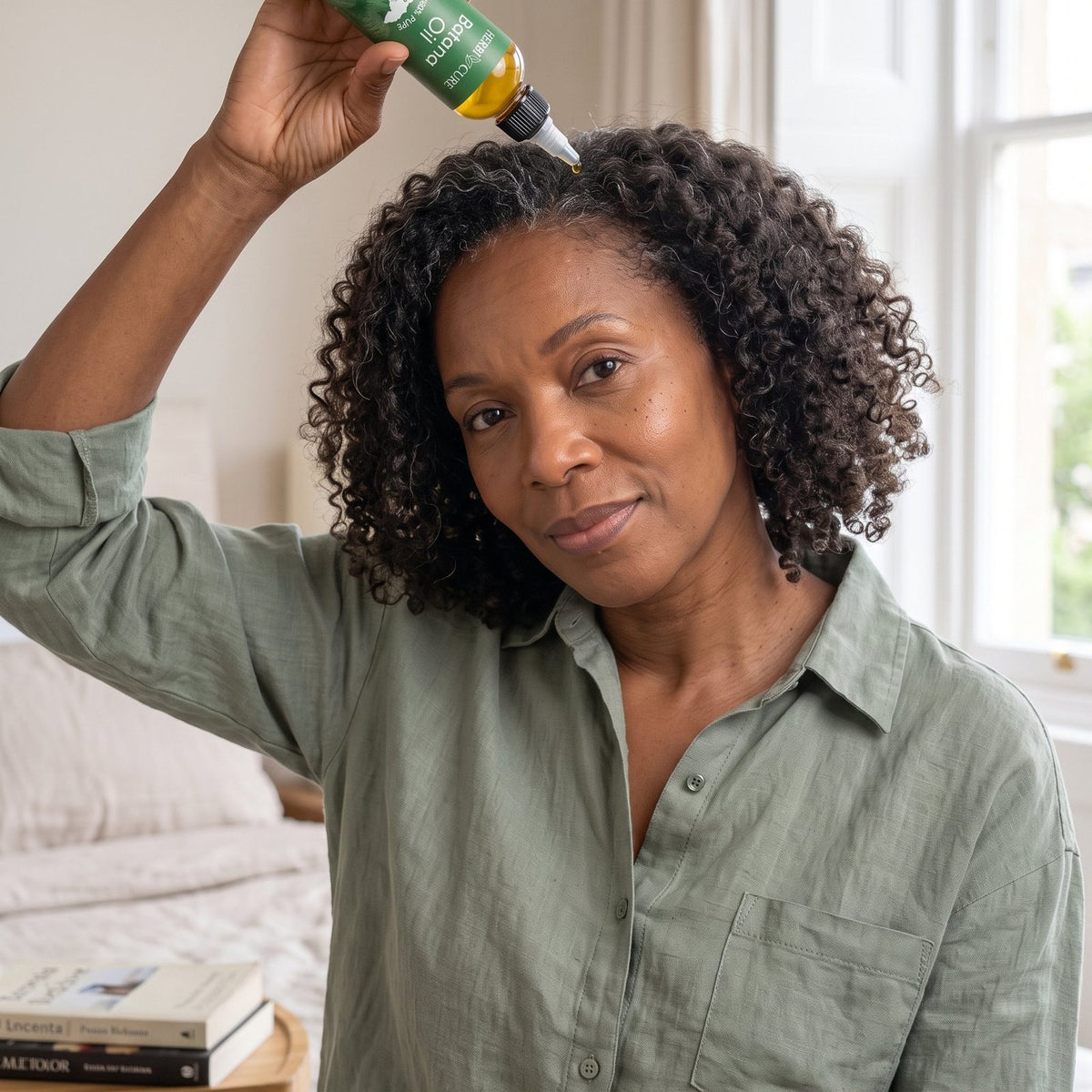 Woman applying batana oil at her hairline